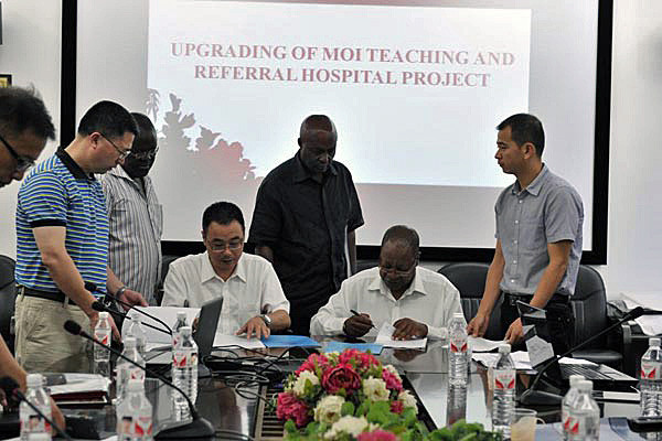 The chief executive of the Moi Teaching and Refrral Hospital Dr John Kibosia (seated right) signs an MoU for the project design with China Wu Yi representatives in Changsha China. Mr Ojwang (in black shirt) looks on. PHOTO/Correspondent