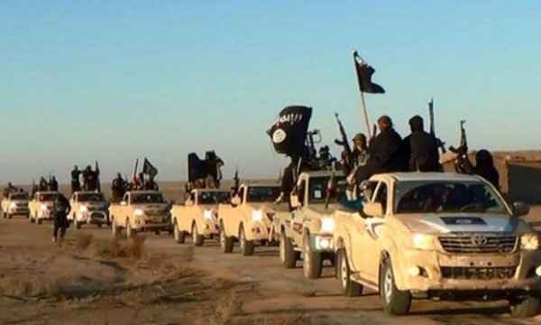 In this undated photo released by a militant website, which has been verified and is consistent with other AP reporting, militants of the Islamic State group hold up their weapons and wave its flags on their vehicles in a convoy on a road leading to Iraq, while riding in Raqqa city in Syria. The Islamic State group is notorious for the atrocities it committed as it overran much of Syria and neighboring Iraq. But to its supporters, it is engaged in an ambitious project: building a new nation ruled by what radicals see as "God's law," made up of Muslims from around the world whose old nationalities have been erased to unite in the "caliphate." (Militant website via AP)