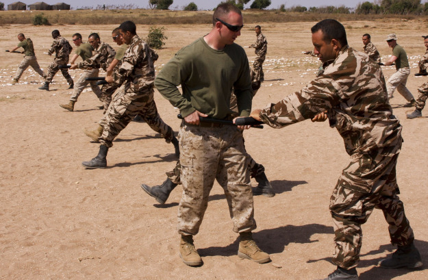 TIFNIT, Morocco – Cpl. Mark Stickney of Blaine, Minn., a field military policeman and martial arts instructor serving with the Military Police Company, Headquarters Battalion, 4th Marine Division assists Moroccan Army personnel to correctly apply riot control baton techniques during a period of instruction on non-lethal weapon techniques presented on Tifnit military base, Morocco May 17. (USMC photo by Army Sgt. Whitney Houston)