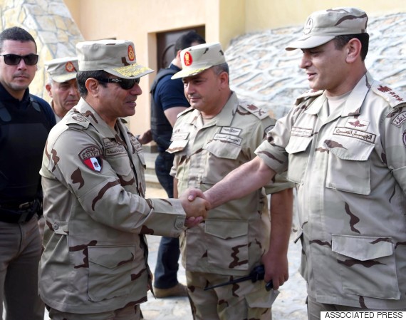 In this picture provided by the office of the Egyptian Presidency, Egyptian President Abdel-Fattah el-Sissi, second left, greets members of the Egyptian armed forces in Northern Sinai, Egypt, Saturday, July 4, 2015.  Egyptian President Abdel-Fattah el-Sissi has travelled to the troubled northern part of the Sinai Peninsula to inspect troops, after Islamic State-linked militants struck a deadly blow against the military this week in a coordinated assault. (Egyptian Presidency /Mohammed Abdel-Muati via AP)