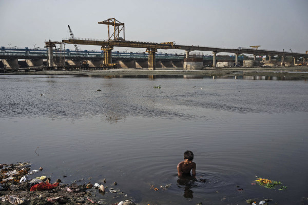 A man looks for coins  thrown in by the pious Hindus along in the river Yamuna along the Okhla Barrage in Delhi, India. The river Yamuna is the primary source of Delhi's water but with high density of population and rapid industrilization, it is one of the most polluted rivers in the world. Photo: Sanjit Das for The Foreign Policy
