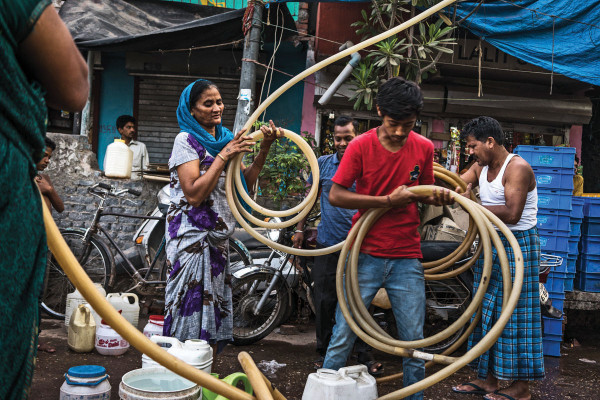 Residents pack their pipes after emptying out the water tanker in the slums of Govind Puri in New Delhi, India. During the peak summer season, the Delhi Jal Board distributes multiple water tankers to the residents in the slum area. Photo: Sanjit Das for The Foreign Policy