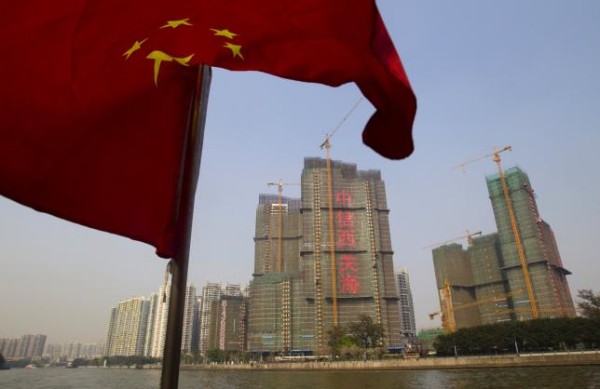 A Chinese national flag flutters on the Pearl River near a construction site in Guangzhou, Guangdong province, in this March 27, 2014 file photo.  REUTERS/Alex Lee/Files