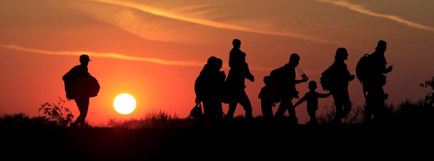 Migrants walk along in the sunset after crossing into Hungary from the border with Serbia near Roszke, Hungary, August 30, 2015. About 100,000 migrants, many of them from Syria and other conflict zones in the Middle East, have taken the Balkan route into Europe this year, heading via Serbia for Hungary and Europe's Schengen zone of passport-free travel. REUTERS/Bernadett Szabo TPX IMAGES OF THE DAY