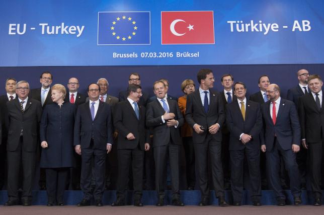 Turkish Prime Minister Ahmet Davutoglu (C) poses with European Union leaders during a EU-Turkey summit in Brussels, as the bloc is looking to Ankara to help it curb the influx of refugees and migrants flowing into Europe, March 7, 2016. REUTERS/Yves Herman