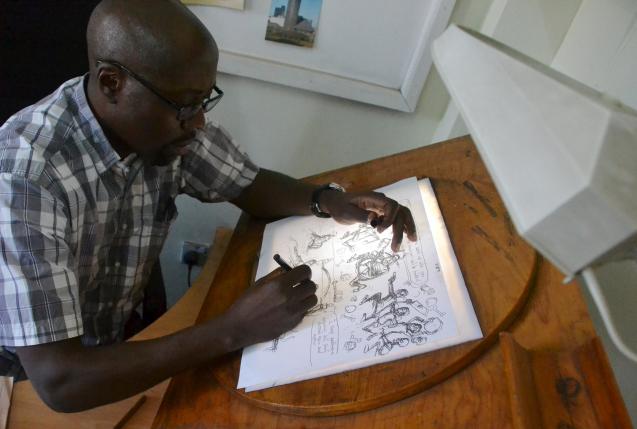 Cartoonist Godfrey Mwampembwa draws in his office in Kenya's capital Nairobi July 21, 2016. To match KENYA-MEDIA/ REUTERS/Drazen Jorgic
