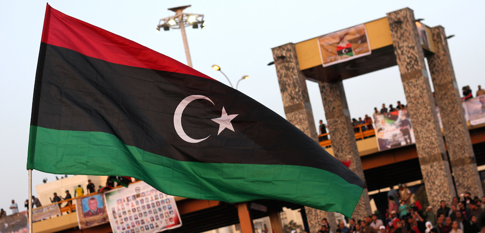 The new Libyan flag is raised during a parade in the eastern city of Benghazi to celebrate the second anniversary of Nato's first military operation in Libya on March 19, 2013. On 19 March 2011, Kadhafi's troops and tanks entered the city and the same day French forces began an international military intervention in Libya, later joined by coalition forces with strikes against armoured units south of Benghazi and attacks on Libyan air-defence systems, after UN Security Council Resolution 1973 called for using "all necessary means" to protect Libyan civilians and populated areas from attack by government forces.  AFP PHOTO / ADBULLAH DOMA        (Photo credit should read ABDULLAH DOMA/AFP/Getty Images)