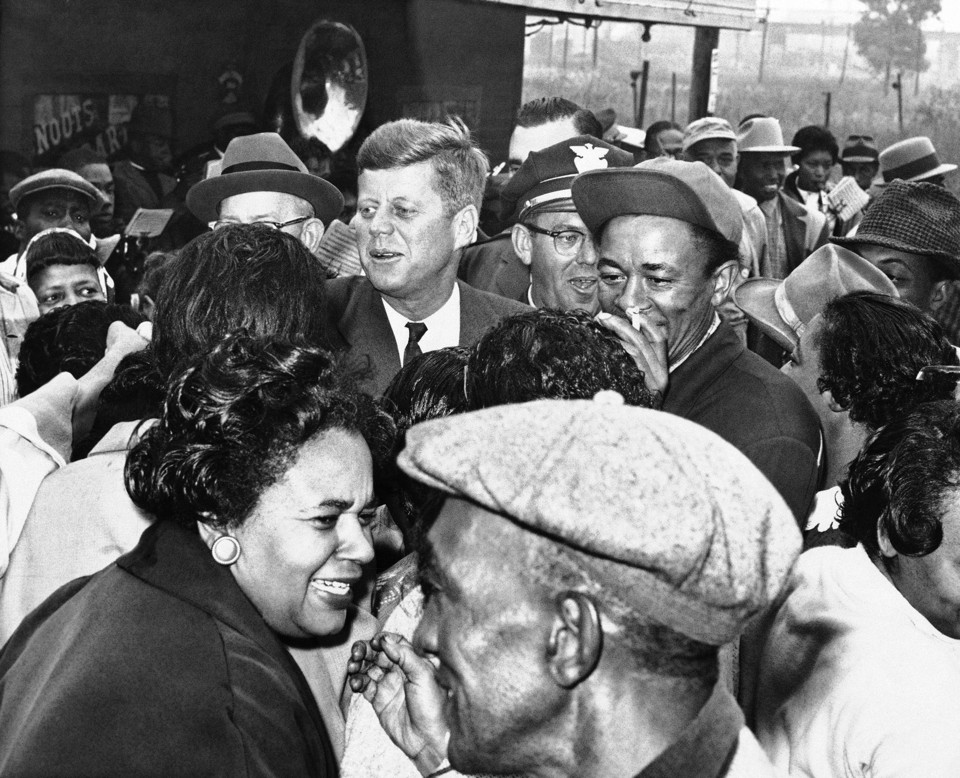 Sen. John F. Kennedy greets residents of the all African American community of Brooklyn, a suburb of East St. Louis, during campaign tour of Southern Illinois, Oct. 3, 1960 in St. Louis, Ill. The democratic presidential nominee and not scheduled a stop there but when he noticed a crowd had turned out with a brass band, he stopped anyway and greeted many of them personally. (AP Photo/Bob Scott)