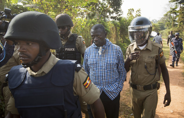 Uganda's main opposition leader Kizza Besigye, center, is arrested by police and thrown into the back of a blacked-out police van which whisked him away and was later seen at a rural police station, outside his home in Kasangati, Uganda Monday, Feb. 22, 2016. Besigye was arrested again Monday as he tried to leave his home, in which he had already been placed under house arrest, as he attempted to visit the election commission's headquarters in Kampala to get detailed copies of the results from the country's presidential election. (AP Photo/Ben Curtis)