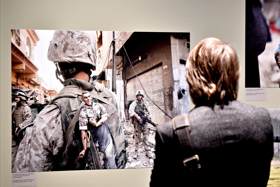 A visitor watches a photo of Associated Press photographer Anja Niedringhaus at the Leica exhibition hall during the photo fair Photokina in Cologne, Germany, Thursday, Sept. 18, 2014. Niedringhaus was killed by an Afghan policeman in Afghanistan last April. Photokina is open until Sept. 21, 2014. (AP Photo/Martin Meissner)