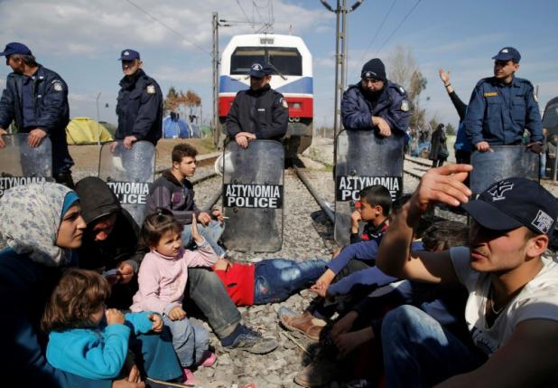 Migrants block the railway track at the Greek-Macedonian border, near the village of Idomeni, Greece March 3, 2016. REUTERS/Marko Djurica