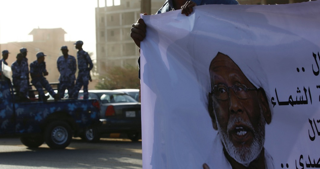 A mourner holds a banner bearing a portrait of Veteran Sudan Islamist opposition leader Hassan al-Turabi during his funeral on March 6, 2016 in the capital Khartoum. Turabi, one of the fiercest critics of President Omar al-Bashir's government, died of a heart attack on March 5 aged 84, officials said. / AFP / ASHRAF SHAZLY (Photo credit should read ASHRAF SHAZLY/AFP/Getty Images)