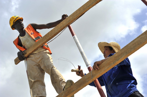 Workers assemble a structure at the Mombasa Standard Gauge Railway (SGR) terminal at KM 0, where goods coming from freighters will be uploaded onto freight trains travelling along the new Mombasa-Nairobi rail line, in Mombasa, Kenya, on Tuesday, March 15, 2016. By providing an alternative to roads, the 1,100-kilometer (684-mile) Chinese-financed railway will slash the time and cost of transporting people and goods between East Africa's landlocked nations. Photographer: Riccardo Gangale/Bloomberg