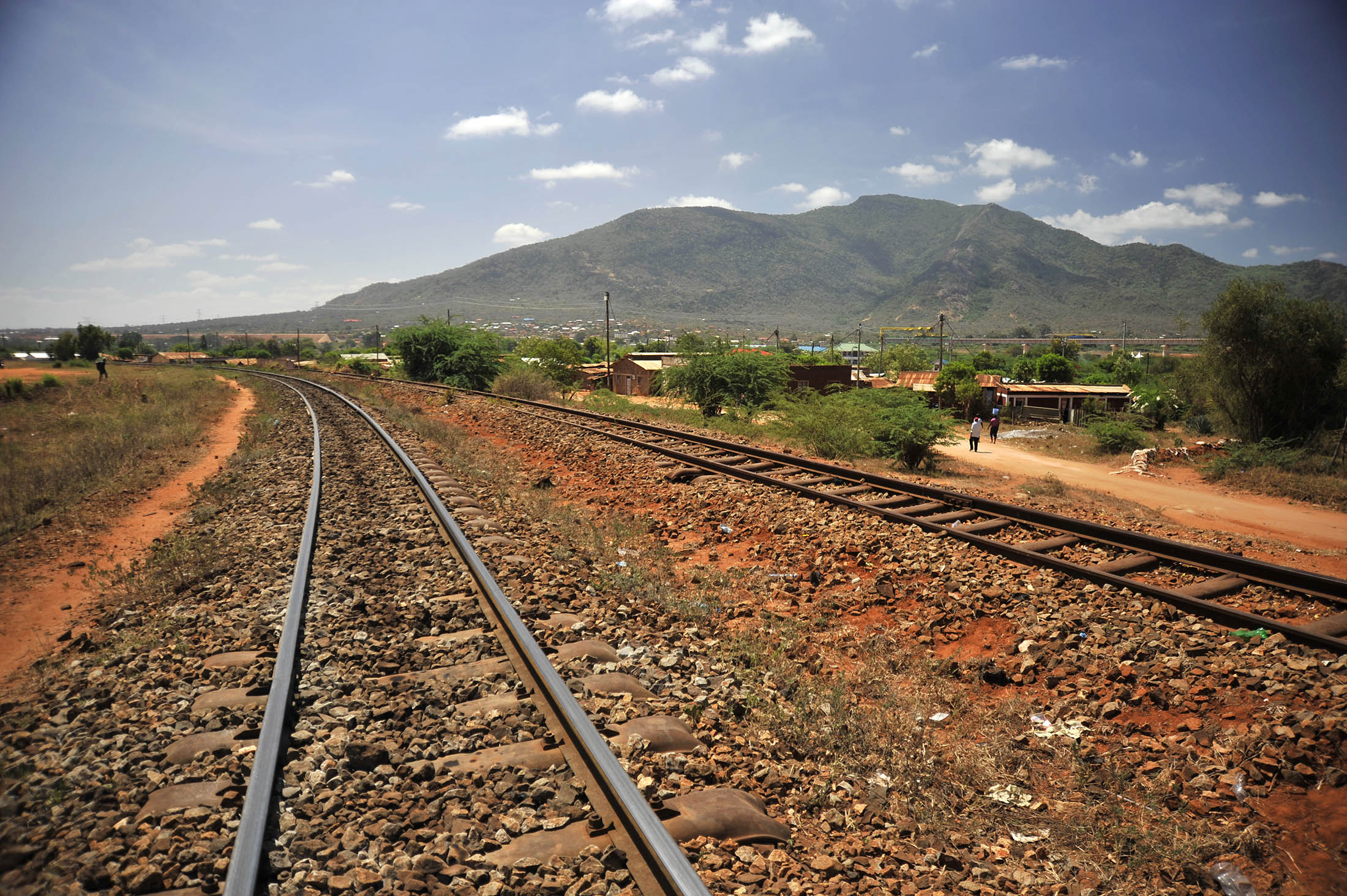 An old colonial-era railway line sits near the site of the new Mombasa-Nairobi Standard Gauge Railway (SGR) line under construction in Voi, Kenya, on Wednesday, March 16, 2016. By providing an alternative to roads, the 1,100-kilometer (684-mile) Chinese-financed railway will slash the time and cost of transporting people and goods between East Africa's landlocked nations. Photographer: Riccardo Gangale/Bloomberg