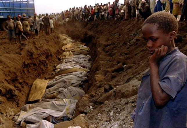 File photo of a Rwandan refugee girl staring at a mass grave where dozens of bodies have been laid to rest July 20, 1994. REUTERS/Corinne Dufka
