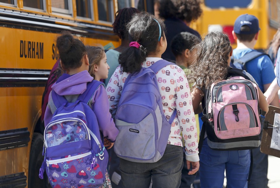 Students at Albany School of Humanities wait to board a bus after school on Monday, April 13, 2015, in Albany, N.Y. With standardized English tests set to begin Tuesday in New York schools, some parents are again planning to have their children sit out the exams. (AP Photo/Mike Groll)