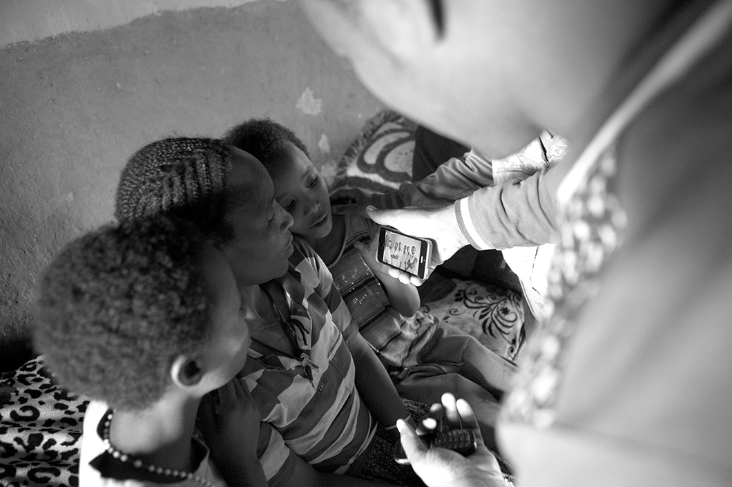 Ayelech Erdado, mother of Abraham, looks at a photo of her other son in prison in Marsabit, Kenya.