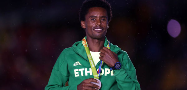 RIO DE JANEIRO, BRAZIL - AUGUST 21: Silver medalist Feyisa Lilesa of Ethiopia stands on the podium during the medal ceremony for the Men's Marathon during the Closing Ceremony on Day 16 of the Rio 2016 Olympic Games at Maracana Stadium on August 21, 2016 in Rio de Janeiro, Brazil. (Photo by Ezra Shaw/Getty Images)